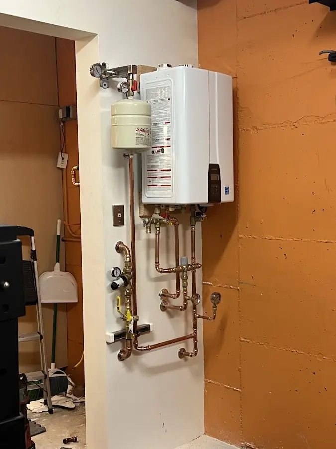 Plumbing technician inspecting water heater connections in Berryville